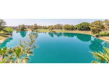 Expansive lake view with calm, blue waters reflecting the surrounding trees and sky at 5102 N 31St Pl # 436, Phoenix, AZ 85016