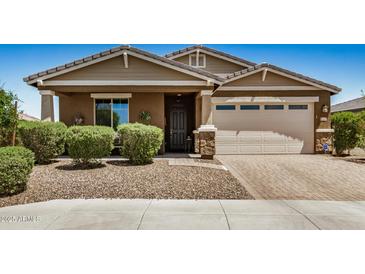Charming single-story home with a well-manicured front yard, a stone-accented facade, and a two-car garage on a sunny day at 531 S 198Th Ave, Buckeye, AZ 85326