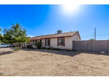 Exterior of a single-story home with a spacious yard and a partial block wall at 7357 W Cheryl Dr, Peoria, AZ 85345