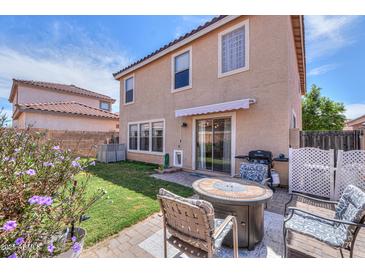 Outdoor patio with a fire pit and chairs, plus grass area and block fence at 3433 S Chaparral Rd, Apache Junction, AZ 85119