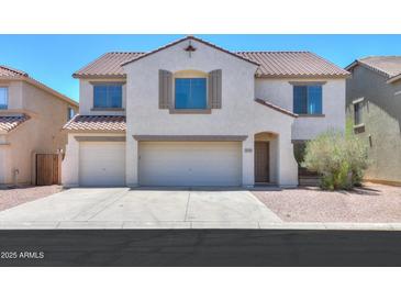 Inviting two-story home featuring a three-car garage, desert landscaping, and a neutral color palette at 43601 W Cowpath Rd, Maricopa, AZ 85138