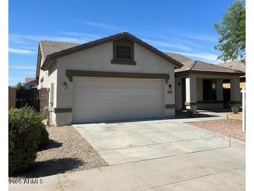 Charming single-story home featuring a two-car garage, a modern roof, and a well-maintained front yard at 15461 W Jefferson St, Goodyear, AZ 85338