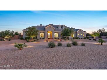 Stunning single-Gathering home featuring well-maintained landscaping and excellent curb appeal at twilight at 20213 W Amelia Ave, Buckeye, AZ 85396