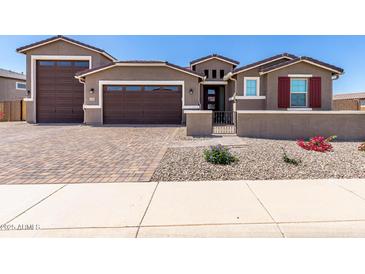 Inviting single-Gathering home with charming exterior and three car garage, featuring desert landscaping at 22386 N Daniel Dr, Maricopa, AZ 85138