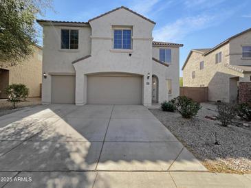 Two-story home featuring a three-car garage, neutral stucco, and desert landscaping in front at 30271 W Crittenden Ln, Buckeye, AZ 85396