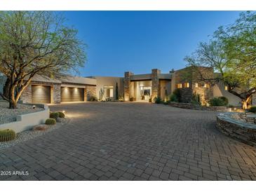 Stunning custom home with stone accents, desert landscaping and paver driveway creates inviting curb appeal at 41611 N 113Th Pl, Scottsdale, AZ 85262