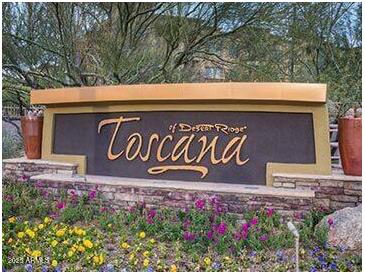 Community sign for Toscana of Desert Ridge with colorful flowers and plants around its base at 5450 E Deer Valley Dr # 1201, Phoenix, AZ 85054