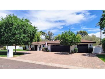 Beautiful single-story home with lush landscaping, brick driveway, and attached garage at 8031 N 12Th Ave, Phoenix, AZ 85021