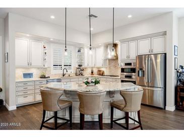 Bright kitchen boasts a large island with seating, stainless steel appliances, and ample cabinet space at 13450 E Via Linda St # 1019, Scottsdale, AZ 85259