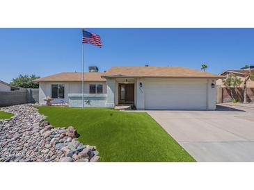 Charming single-story home featuring an American flag, rock landscaping, and a well-maintained lawn at 4621 E Mineral Rd, Phoenix, AZ 85044