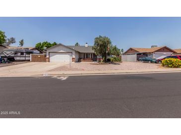 Cozy single-story home featuring a two-car garage, desert landscaping, and a brick-accented facade at 6110 E Ivyglen St, Mesa, AZ 85205