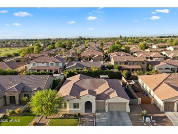 Expansive aerial view of a beautiful suburban home in a well-maintained neighborhood with mountain views in the distance at 3574 E Tonto Pl, Chandler, AZ 85249