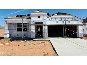 New home's exterior showing the initial stages of construction with scaffolding, roofing tiles, and wrapped insulation at 5064 E Midnight Star Dr, San Tan Valley, AZ 85143