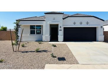 Charming single-story home featuring a black garage door and a well-maintained gravel front yard at 5064 E Midnight Star Dr, San Tan Valley, AZ 85143
