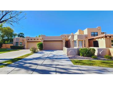 Charming Southwest-style home featuring a three-car garage, desert landscaping, and a tile roof at 5756 N 78Th Pl, Scottsdale, AZ 85250