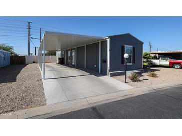 Exterior of home featuring covered parking, landscaped yard, and gray siding at 10951 N 91St Ave # 6, Peoria, AZ 85345