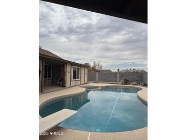 Backyard pool with diving board and partially covered patio area perfect for entertaining or relaxing at 12512 N 85Th Ave, Peoria, AZ 85381