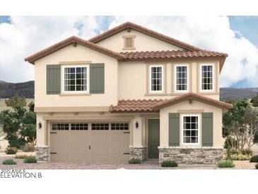Charming two-story home with tan stucco, a red tile roof, stone accents, and green shutters at 17016 W Winston Dr, Goodyear, AZ 85338