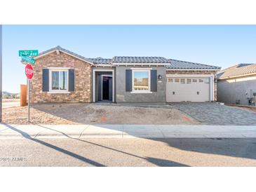 Charming single-story home showcasing stone accents, gray shutters, tile roof, and a paved driveway at 18840 N 269Th Ave, Buckeye, AZ 85396