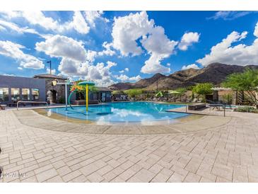 Relaxing community pool featuring plenty of seating, splash pad and mountain views at 21412 W Hubbell St, Buckeye, AZ 85396