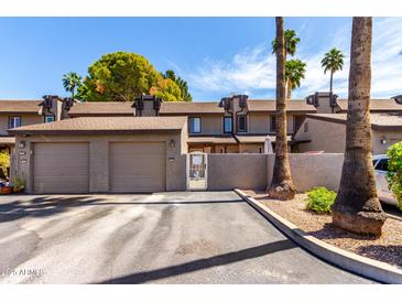 Attractive townhome exterior with private garage and gated courtyard entrance and mature landscaping at 2232 W Lindner Ave # 20, Mesa, AZ 85202
