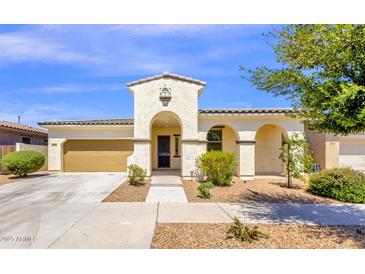 Charming single-story home with a two-car garage, arched entryway, and well-maintained front yard at 22472 E Sonoqui Blvd, Queen Creek, AZ 85142