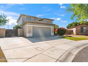 Charming two-story home with a gray garage door, stone accents, and well-maintained landscaping at 345 N Scott Dr, Chandler, AZ 85225