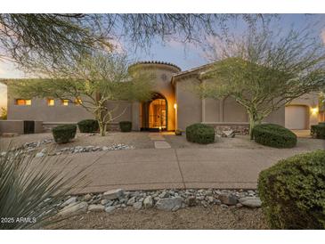 Elegant home entrance featuring a secure gated entryway, mature landscaping, and a desert-style front yard at 12006 E Yucca St, Scottsdale, AZ 85259