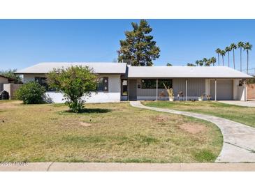 Charming single-story home with well-maintained lawn and inviting walkway, offering classic curb appeal at 2740 N 21St Dr, Phoenix, AZ 85009