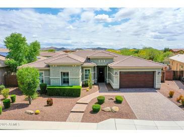 Stunning single-story home featuring a well-manicured front yard and a two-car garage with brick paver driveway at 30909 N 27Th Ave, Phoenix, AZ 85085