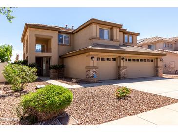 Two story home showcasing a three-car garage, beautiful landscaping, and a charming entrance at 6967 W Potter Dr, Glendale, AZ 85308