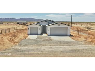 Charming single-story home with a symmetrical facade, two-car garage, and desert landscaping at 25893 W Running Deer Trl, Wittmann, AZ 85361