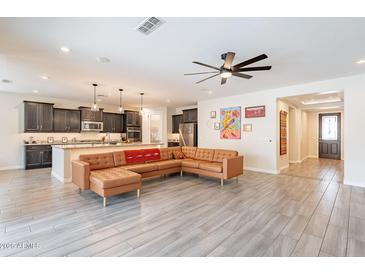 Open floor plan featuring tile floors, modern lighting, and seamless transition into the kitchen at 3720 E Narrowleaf Dr, Gilbert, AZ 85298