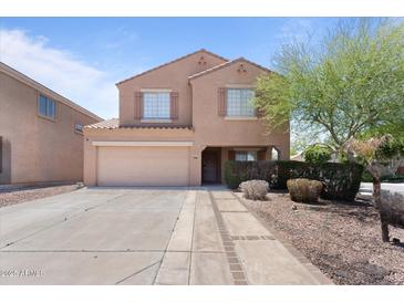 Two-story home featuring stucco siding, two-car garage, and a well-manicured front yard at 10939 W Meadowbrook Ave, Phoenix, AZ 85037