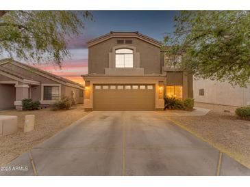 Charming two-story home featuring a spacious driveway, two-car garage, and manicured desert landscaping at 14010 N 126Th Ave, El Mirage, AZ 85335