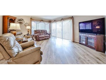 Bright living room featuring hardwood floors, large windows, and comfortable seating at 17404 N 99Th Ave # 318, Sun City, AZ 85373