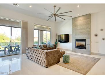 Bright living room features a stone fireplace, large ceiling fan, and glass doors to the outdoor living space at 2106 E Beth Dr, Phoenix, AZ 85042