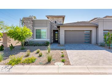 Beautiful single-Gathering home with stone accents, desert landscaping, a gray garage door, and a paved driveway at 2885 N 164Th Dr, Goodyear, AZ 85395