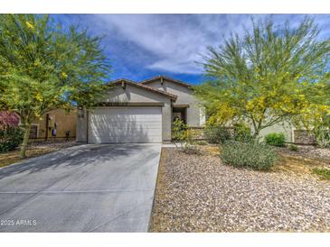 Charming single-story home featuring a two-car garage, desert landscaping, and a welcoming facade at 33974 N Beeblossom Trl, San Tan Valley, AZ 85144