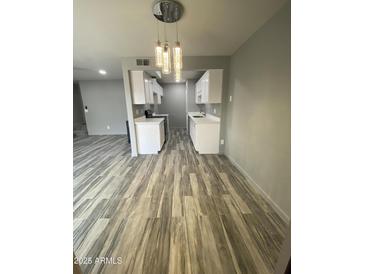 Bright kitchen features sleek white cabinets, modern lighting, and stylish wood-look floors at 6041 W Golden Ln, Glendale, AZ 85302