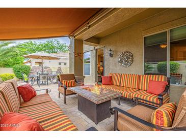 Comfortable covered patio with stylish seating, a fire pit, and views of the manicured outdoor dining area at 6202 E Mckellips Rd # 189, Mesa, AZ 85215