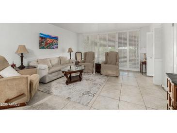 Bright living room with tile floors, neutral furniture, and stylish coffee table at 7625 E Camelback Rd # B124, Scottsdale, AZ 85251