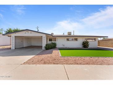 Charming single-story home featuring a carport, low maintenance landscaping, and a bright white exterior at 8044 N 10Th Pl, Phoenix, AZ 85020