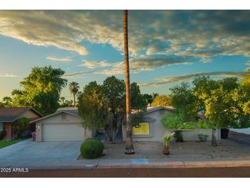 Charming single-story home featuring a two-car garage and mature trees in a well-maintained front yard at 8338 E Monterosa St, Scottsdale, AZ 85251