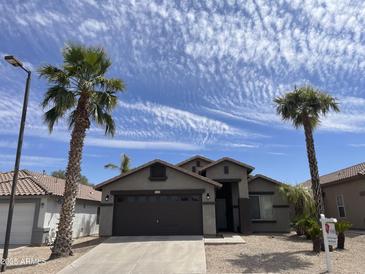 Charming single-story home with a desert landscape, palm trees, and a two-car garage at 3229 W Five Mile Peak Dr, San Tan Valley, AZ 85144