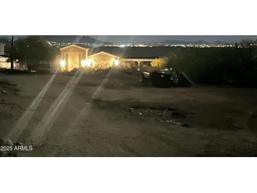 Night view of a home's exterior featuring illuminated details and a distant cityscape at 34047 N 10Th St, Phoenix, AZ 85085