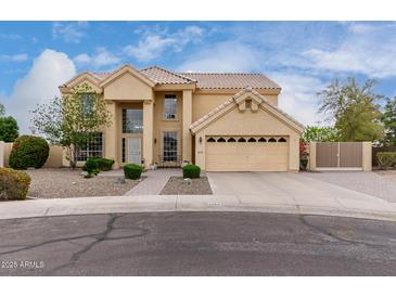 Two-story home featuring a tan exterior, manicured landscaping, and a spacious two-car garage at 4106 E Lavender Ln, Phoenix, AZ 85044