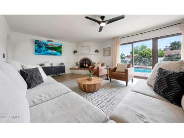 Inviting living room with fireplace, sliding doors to outdoor patio and pool, and comfortable seating at 5001 E Redfield Rd, Scottsdale, AZ 85254