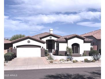 Charming single-story home boasts a well-manicured desert landscape, complemented by a two car garage and a tiled roof at 14253 N Honeysuckle N Dr, Fountain Hills, AZ 85268