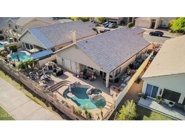 Aerial view of a backyard with a pool, patio, and outdoor kitchen, ideal for entertaining and relaxation at 1437 E Glenhaven Dr, Phoenix, AZ 85048